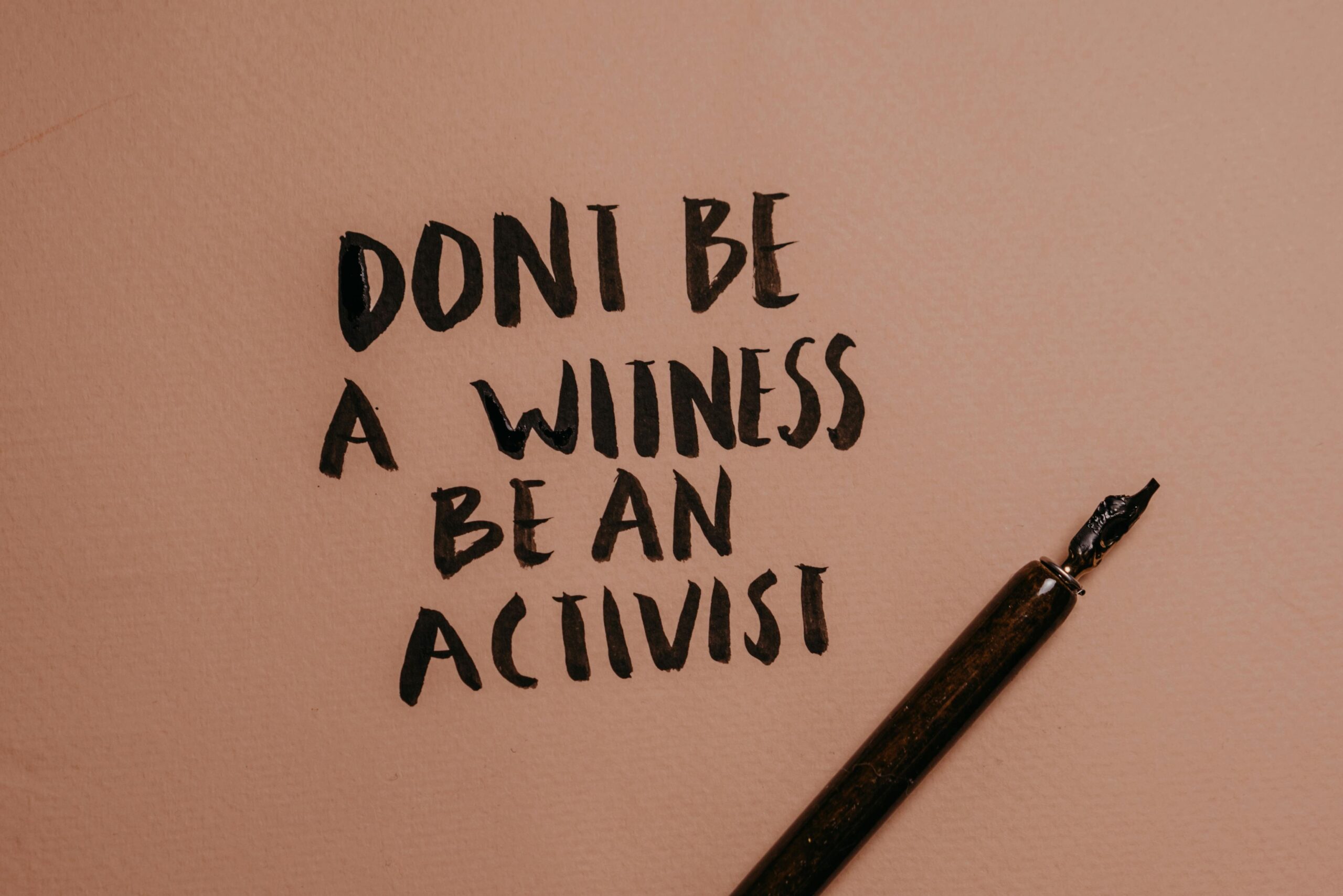 Inspiring handwritten quote with a fountain pen encouraging activism.